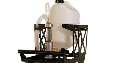 A large white plastic jug sits in a black metal caddy, with a silver pump and clear tubing attached in the foreground.